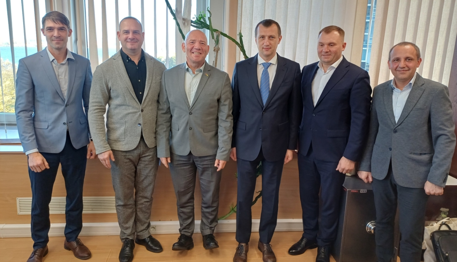 Klasiski ģērbti vīrieši, tehniskās uzraudzības pārstāvji no Latvijas un Ukrainas