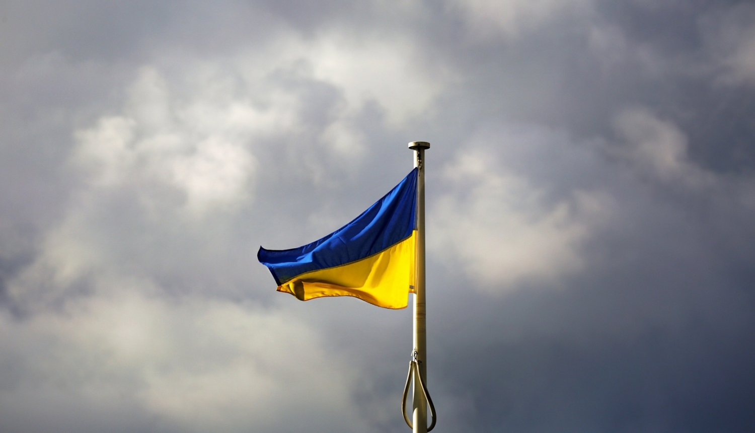 UA zili dzeltenais karogs pret mākoņainām debesīm